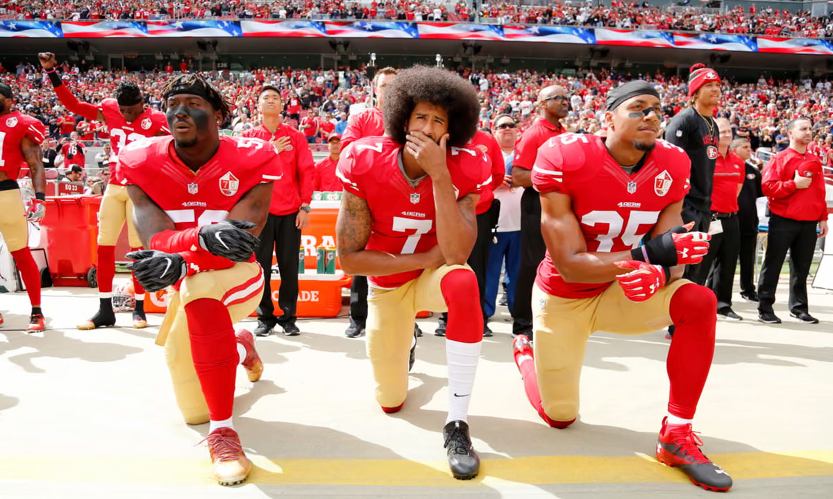 Colin Kaepernick, flanked by Eli Harold and Eric Reid, takes a knee before an NFL game in October 2016. Photograph: John G Mabanglo/EPA